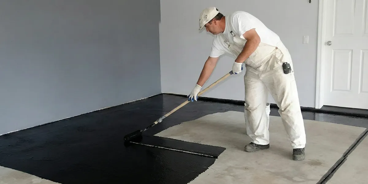 basement waterproofing professional applying waterproof coating to protect a basement floor in Anaheim, CA
