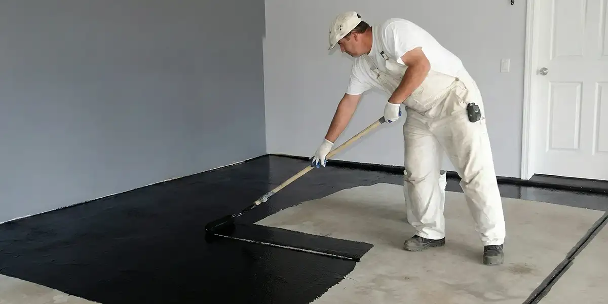 basement waterproofing professional applying waterproof coating to protect a basement floor in Anaheim, CA
